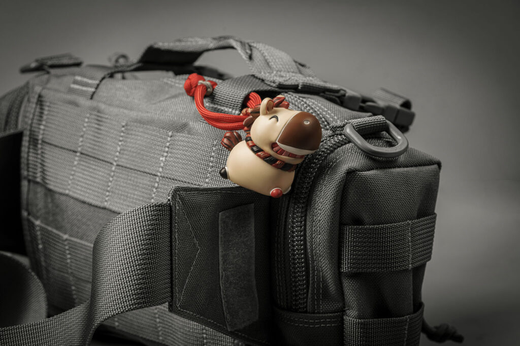 Dawn Hoof Charm in Zen Abode clipped to a grey backpack