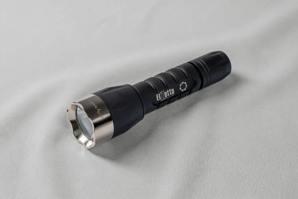 Elzetta flashlight fitted with a crenellated stainless steel bezel